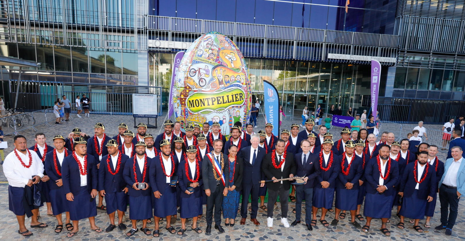 L'équipe des Samoa devant l'hôtel de Ville et le ballon de rugby signé par l’artiste Franck Célaire 