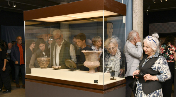 des visiteurs devant une vitrine de l'exposition 